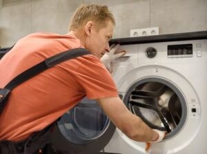 мастер по ремонту стиральных машин проводит диагностику