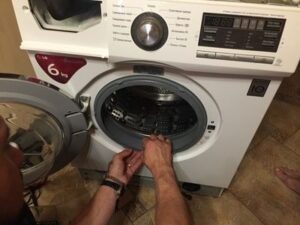 Мастер проверяет целостность манжеты стиральной машины