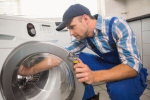 Мастер ремонтирует стиральную машину
