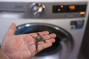 Техник устранил засор сливного фильтра стиральной машины
