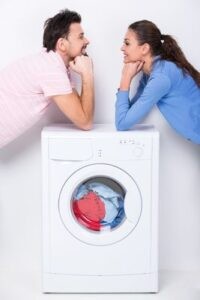 Влюбленная пара радуется тому, что их стиральная машина снова работает после ремонта